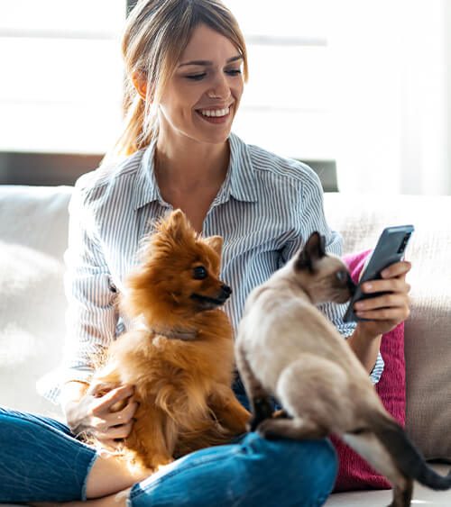 woman on phone with pets nearby